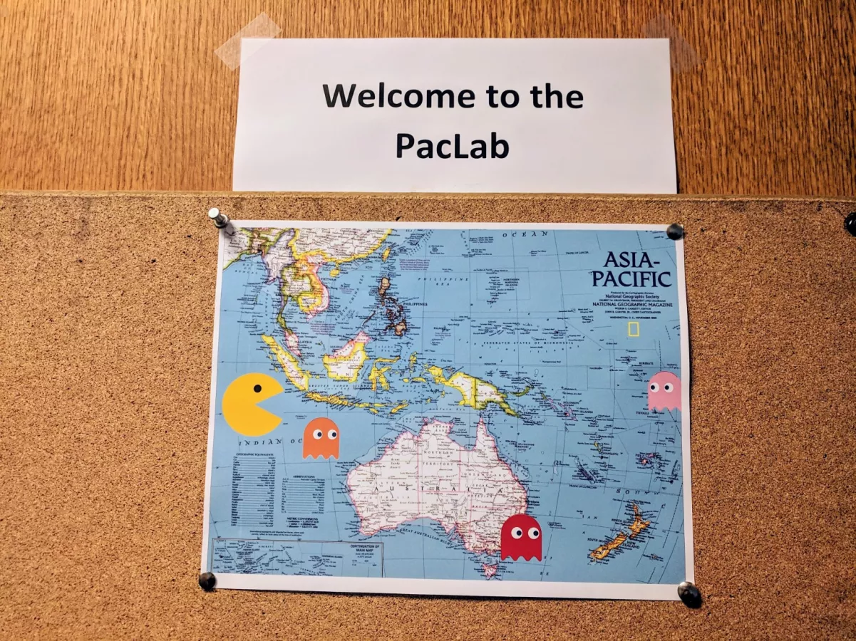 sign with text "Home to the PacLab" followed by map of southwest Pacific region with Pacman chasing colorful ghosts