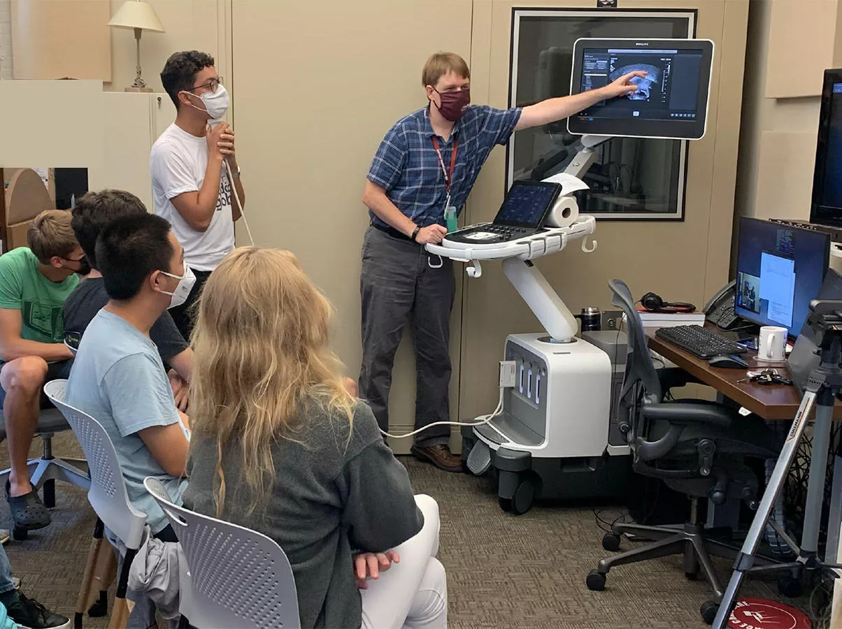 Phonetics lab being used for ultrasound imaging by Jonathan Washington and a class, with consultant holding ultrasound probe below jaw