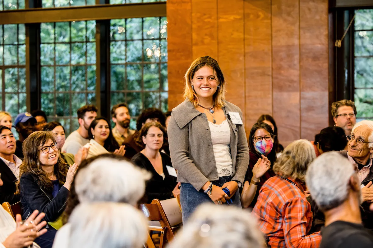 A young woman stands up in a crowd 