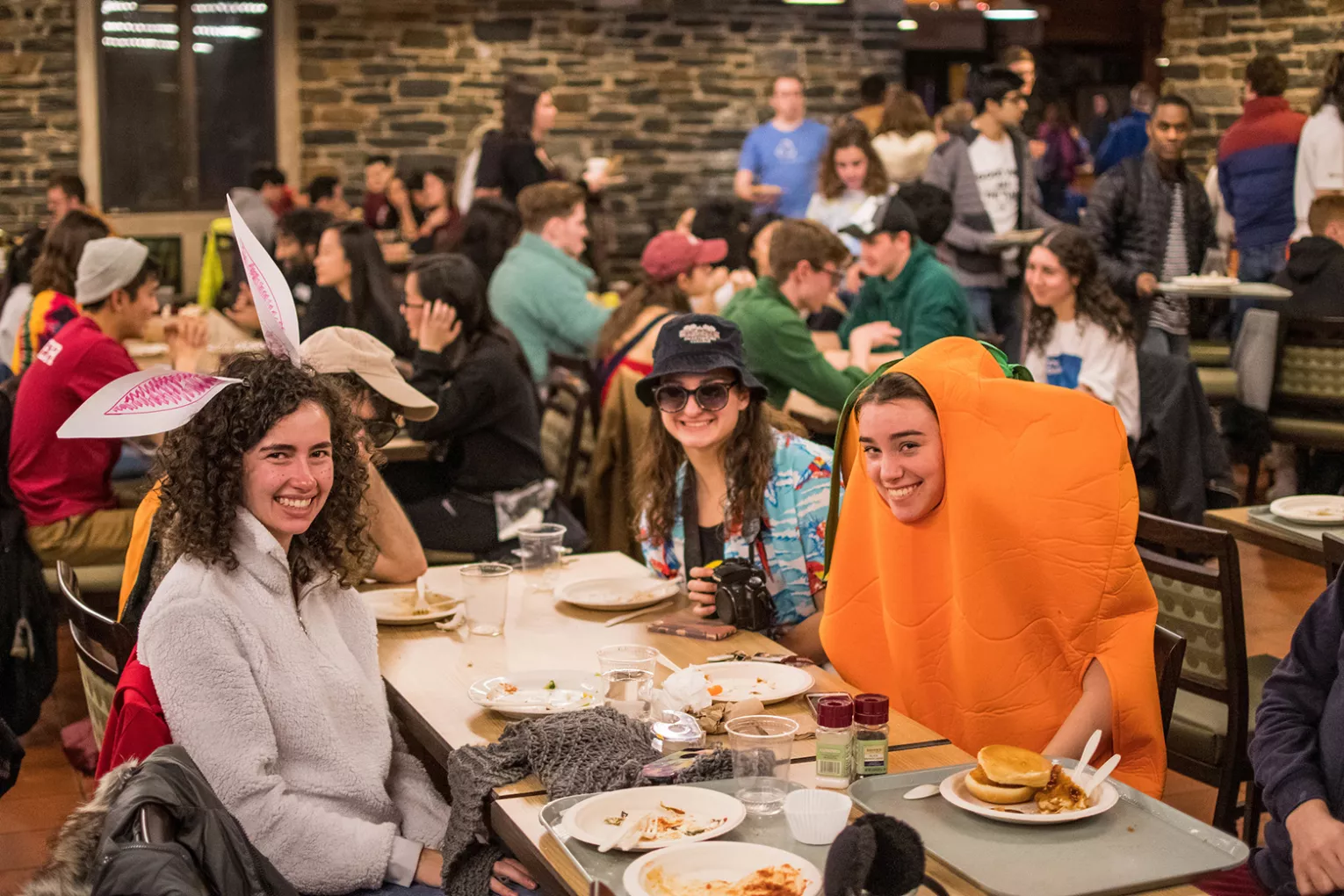 Student dressed as carrot sits at table