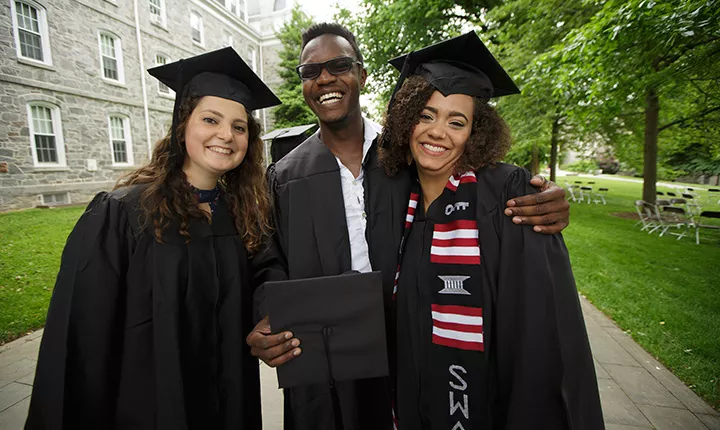 Three students gather following Baccalaureate 2017.