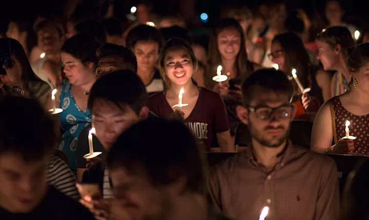 Students stand with their candles