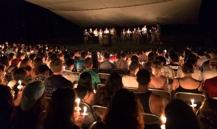 Students sit with their candles at Last Collection