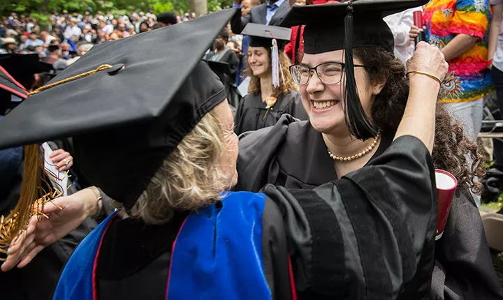 graduate hugging faculty member