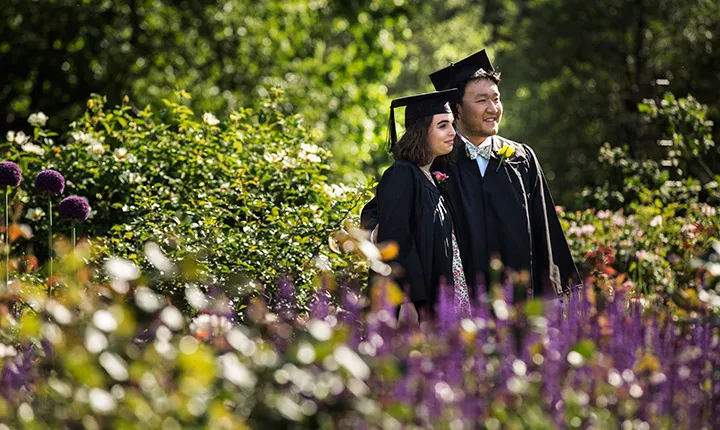 students posing amidst flowers