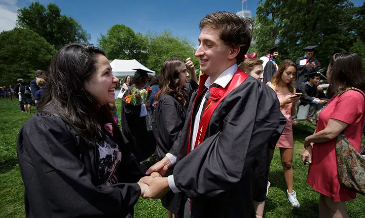 Two graduates holding hands