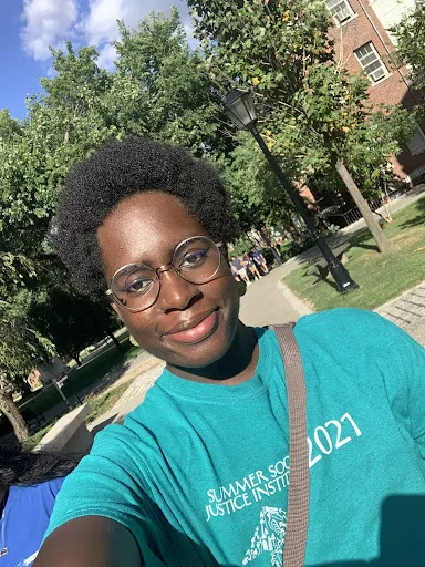 Lemuel wearing a teal t shirt smiling outside