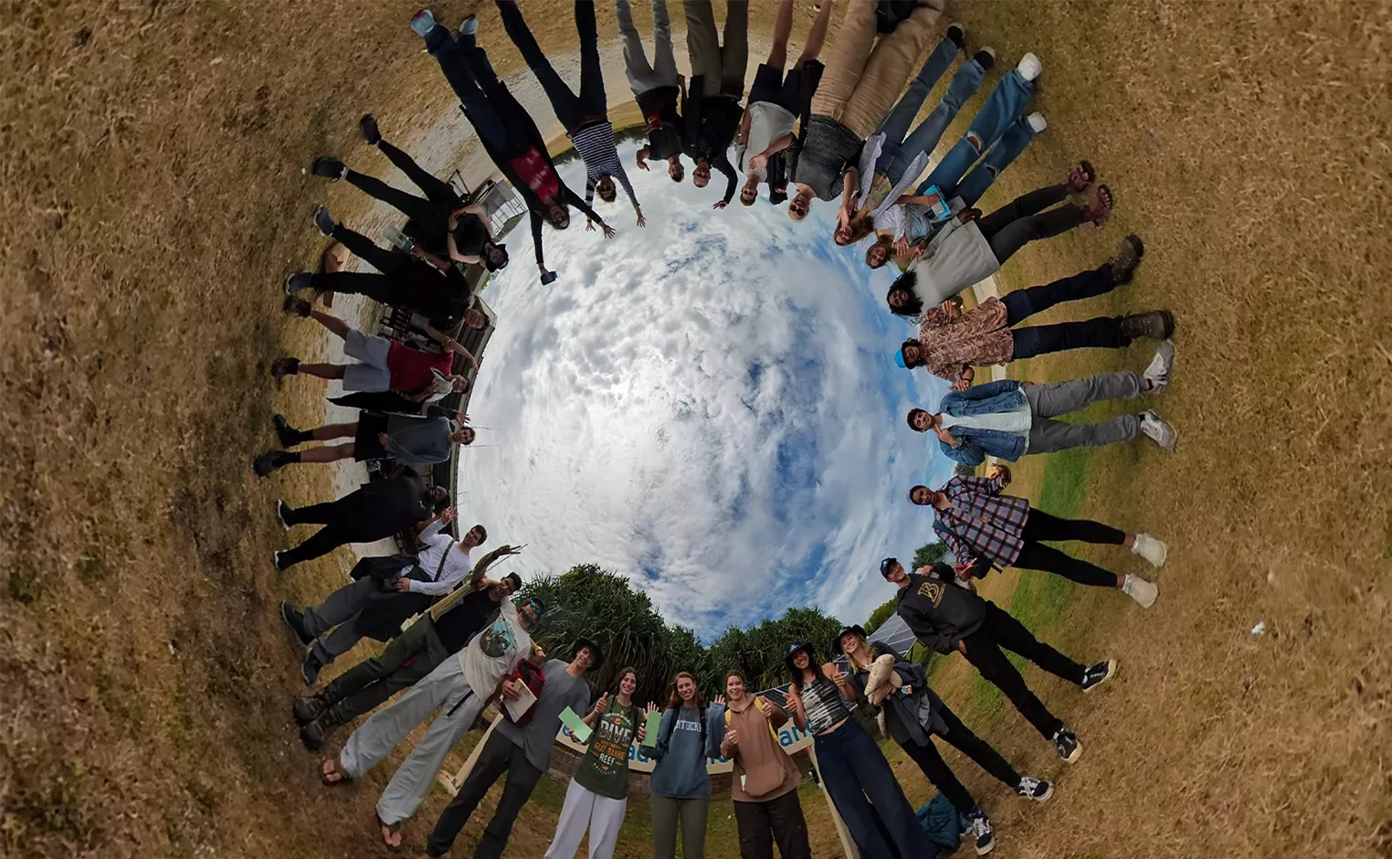 Group standing in circle with sky at center